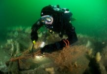 Duikers bergen 750 kilo visnet Duiker verwijdert staand wand - foto: Cor Kuyvenhoven